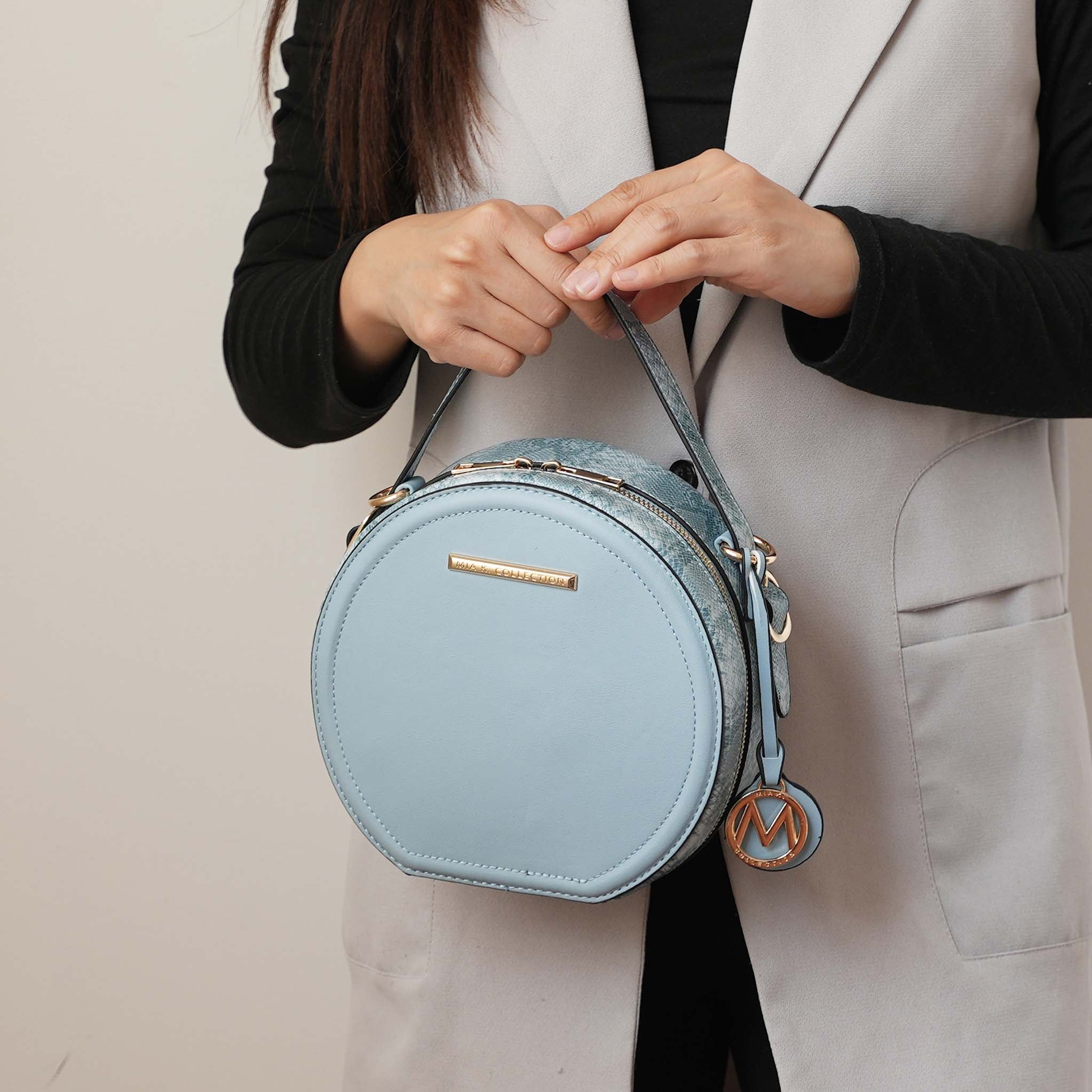 Structured circle crossbody bag in vegan leather with snakeskin gusset trim and gold hardware